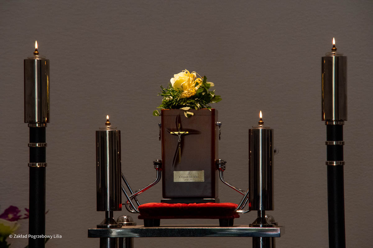 An urn with flowers between candles