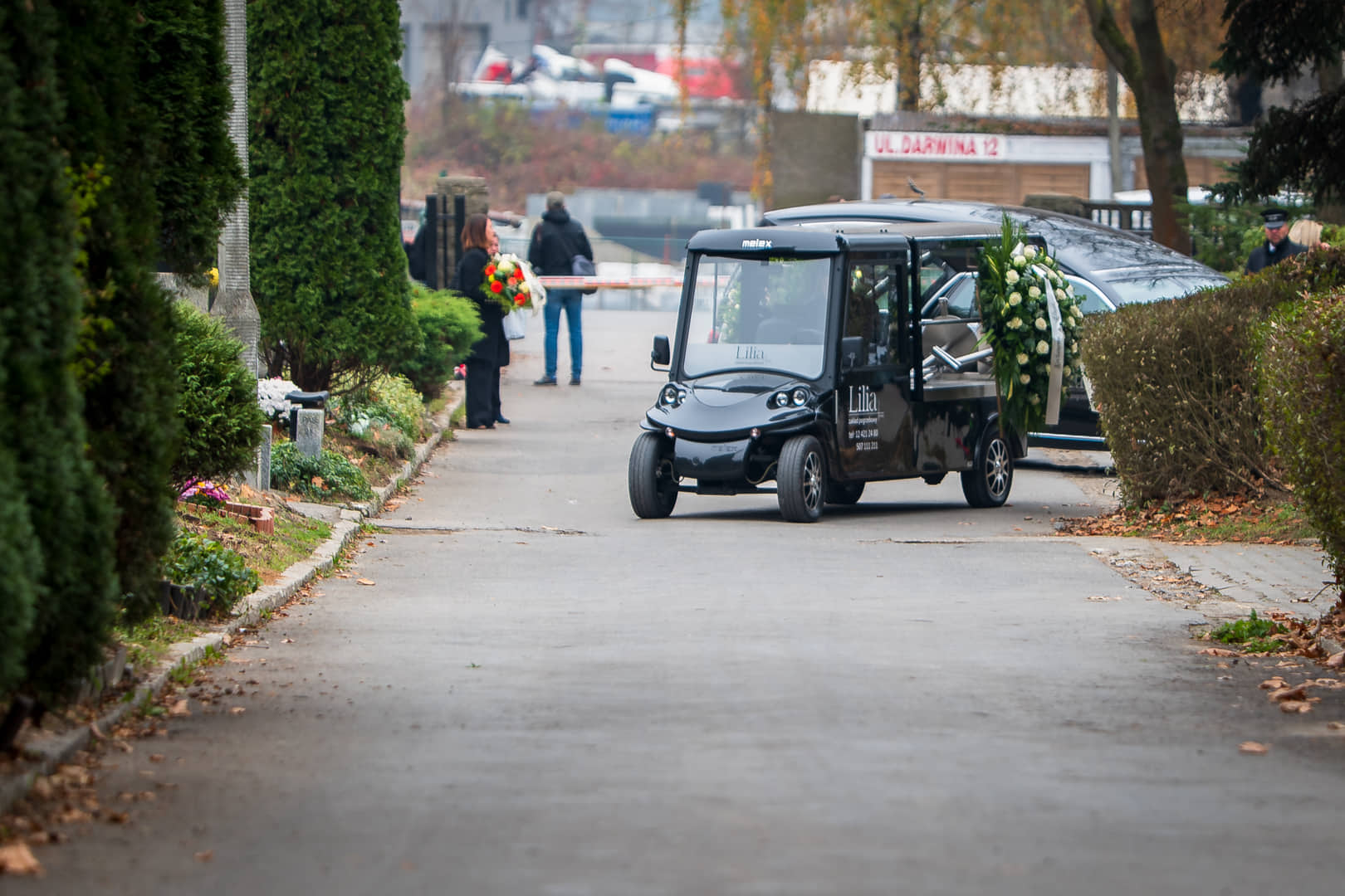Lilia’s electric hearse on a cemetery avenue