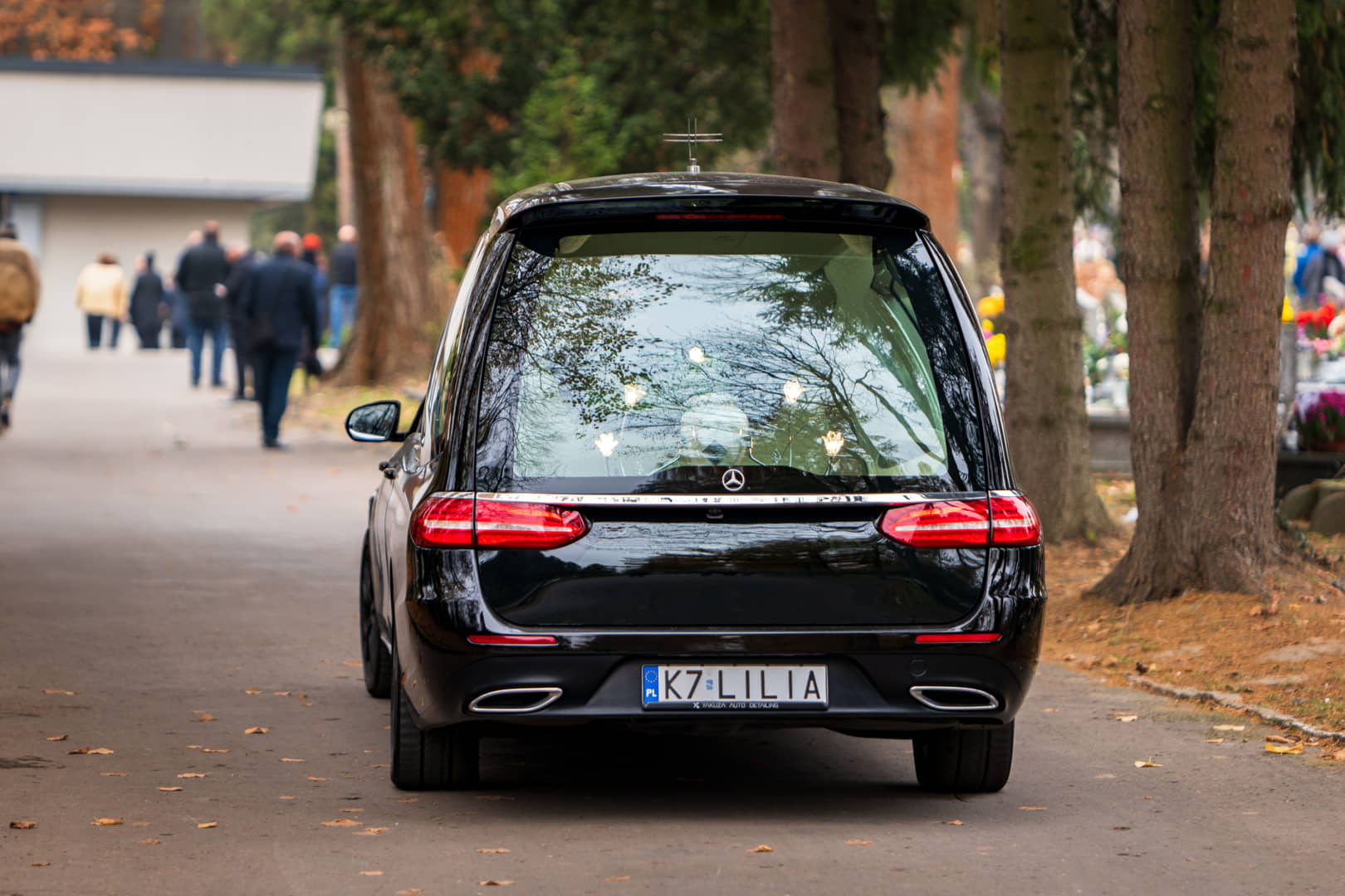 Lilia's hearse in a cemetery avenue