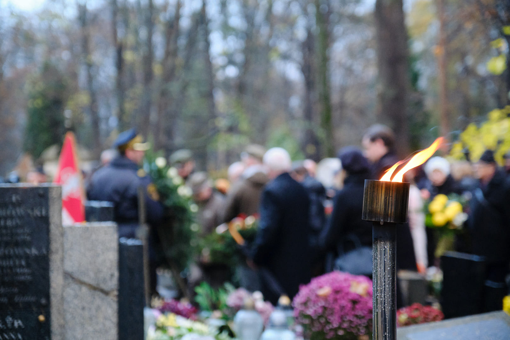 Candles and flowers on a grave during a ceremony
