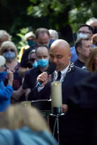 The celebrant with a microphone among the mourners